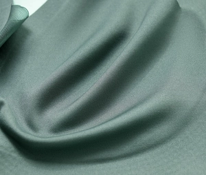 Close-up of sage green seamless knit fabric with ribbed texture and fine mesh detail