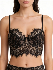 Detail of black lace bustier with eyelash lace trimming and sheer wired cups on model