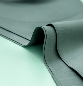 Detail of dark green seamless fabric with matte texture and elastic raw cut edges