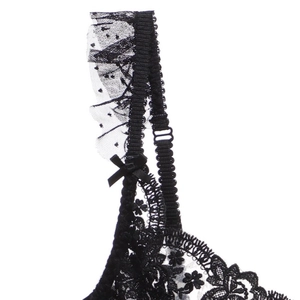 Détail de dentelle florale avec nœud en satin sur la bretelle réglable du soutien-gorge