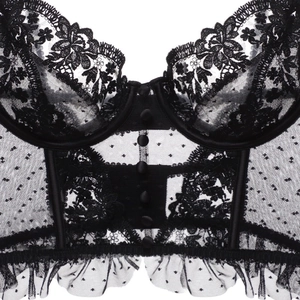 Détail d'un bustier en dentelle noire avec broderies florales et tulle à pois
