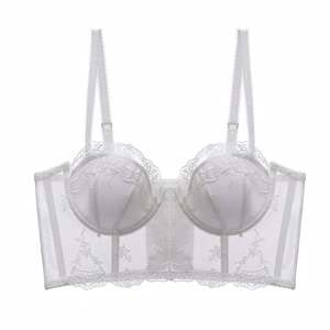 Détail d'un bustier en dentelle brodée blanche avec maille florale et armature souple