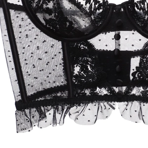 Détail de corset en dentelle noire avec motifs floraux, mesh et boutons sur le devant
