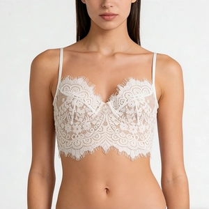 Detailed view of delicate white floral lace patterns with eyelash lace trim on a soft bra
