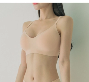 Vista laterale dettagliata del reggiseno beige senza cuciture con scollo a V su modella