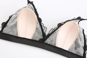 Close-up of black lace bralette detail with rose embroidery and removable beige pads