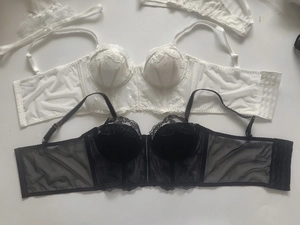 Détail de broderie en dentelle française et mesh transparent sur bustiers noir et blanc
