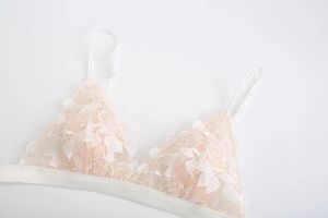Detail of floral embroidery on white wireless French triangle bralette with lace straps