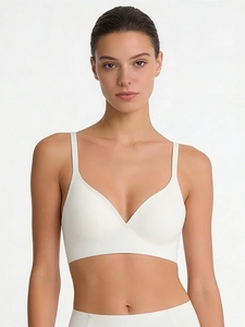 Close-up of white seamless V-neck bra with thin straps on model with smooth fabric