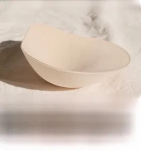 Macro detail of ergonomic beige teardrop bra pads with seamless edges and soft fabric