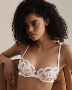 Close-up of white lace bra featuring delicate geometric wave embroidery and sheer texture