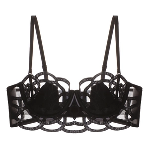 Close-up of black lace bra detail showing intricate circular patterns and scalloped embroidery