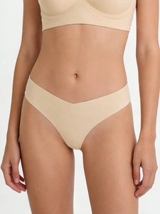 Detail of beige seamless thong with minimalist raw-cut edges and breathable fabric texture