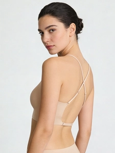 Détail d'un soutien-gorge dos nu beige avec fines bretelles croisées et design sans couture