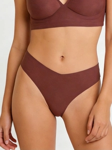 Detail of seamless chocolate brown thong with high-elastic fabric on female model