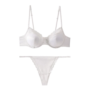 Detailed view of white satin lingerie set with delicate lace trim and elastic straps