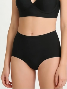 Detail of seamless high-waisted black underwear showing smooth laser-cut edges and fabric texture