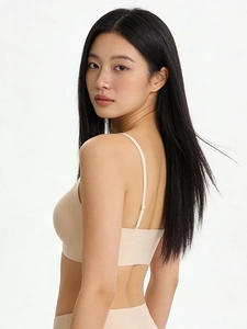 Detail view of seamless beige bralette showing elastic straps and V-neck back design