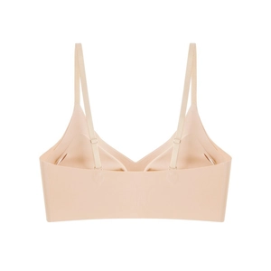 Detail of a beige seamless bralette featuring adjustable straps and wide underband