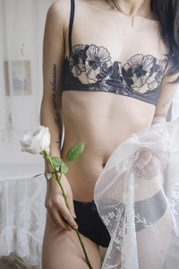 Close-up of floral embroidery on black lace bra and panty set with sheer details