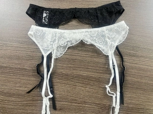Detail of floral lace garter belts in black and white with adjustable elastic straps