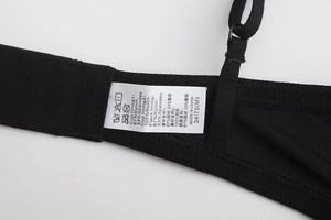 Close-up of the black bra side wing and strap stitching with a clear size and care label