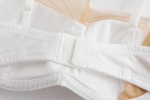 Detail shot of the breathable mesh back strap and secure clasp on the white bra
