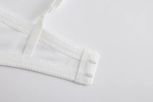 Close-up of white tube top bra featuring double hook-and-eye closure and adjustable straps