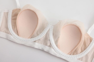 Detail of white lace bra cup featuring breathable mesh lining and drop-shaped sponge padding