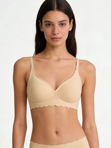 Seamless nude bra set with scalloped edges and wireless support on a studio model