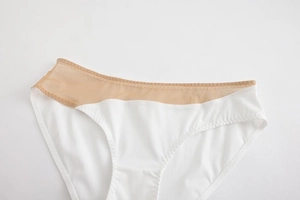 Detail view of seamless white panties with breathable beige mesh waist stitching