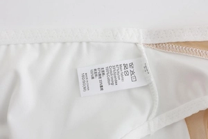 Detail view of lingerie care label showing 67% nylon, 33% spandex and 100% cotton fabric