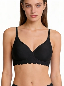 Detail of seamless black wireless bra featuring scalloped wave edges and elastic fabric