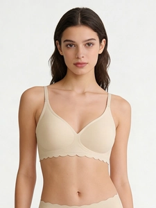 Detail view of seamless wireless nude bra with scalloped edges and adjustable straps