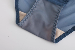 Close-up of blue mesh lace lingerie showing cotton crotch lining and zigzag stitching