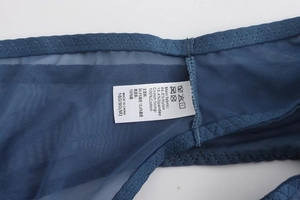 Detailed tag showing 100% cotton lining and blue lace embroidery fabric material