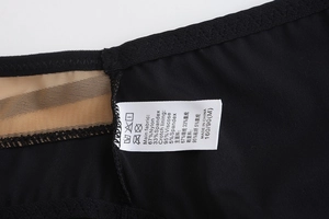 Close-up of seamless black underwear with mesh detail and printed fabric care label