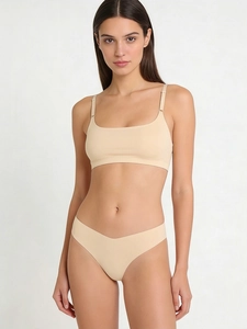 Detailed view of seamless beige lingerie set with adjustable straps and laser-cut edges
