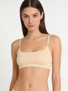 Detail of seamless beige bralette featuring adjustable straps and soft skin-friendly fabric