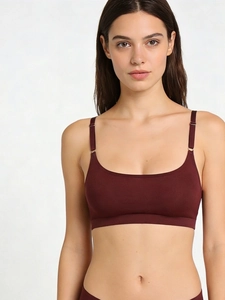 Detailed front view of seamless wine red bralette with adjustable wide straps on model