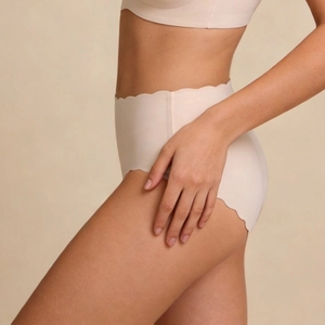 Detail of seamless nude underwear showing wavy scalloped edges and breathable fabric texture