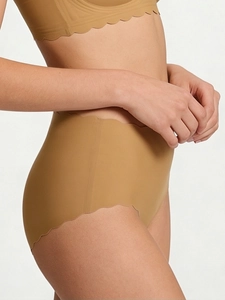 Detail of nude seamless high-waist panties with scalloped wavy edges and soft elastic fabric