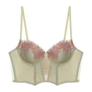 Dettaglio del bustier in raso verde menta con ricamo floreale rosa e lacci sul davanti
