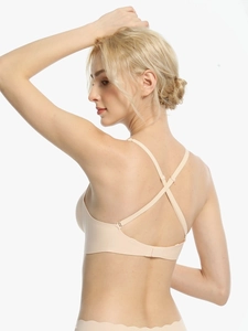 Detail of seamless beige bra with elegant cross-back straps and soft wire-free fabric