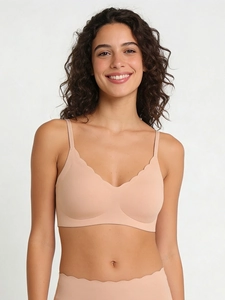 Detail view of seamless beige bra set with wavy scalloped edges and high-elastic fabric