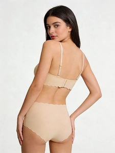 Detail of seamless beige bra set with scalloped edges and high waist panties on model