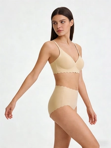 Detail view of seamless beige bra and high-waist panties set with scalloped edges