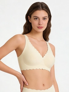 Detail view of seamless deep V-neck bra set with wavy scalloped edges in beige tone