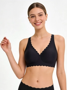 Detail shot of the black seamless bra featuring elegant scalloped edges and deep V-neckline