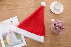 Detailed plush texture of a festive red Christmas hat with a white pompom on a wooden desk